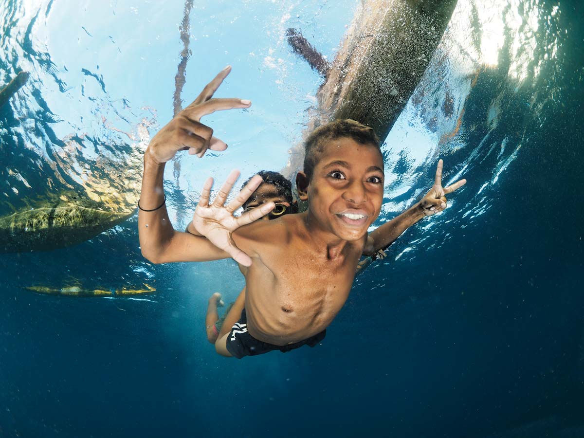 Kids of Alor under the canoes